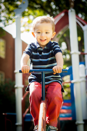 Happy smiling kid playing in the park playgroundの写真素材