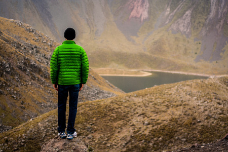 Hiker watching a lake in the mountainの写真素材