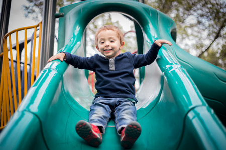 happy little boy on the playground slide.の写真素材