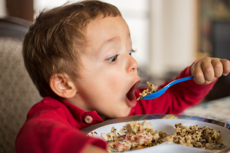 Little boy child eating brown rice and quinoa.の写真素材