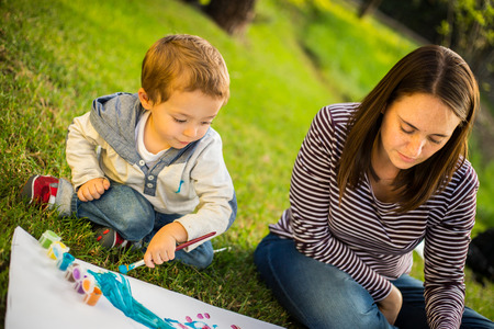Happy Mother and son child painting in the park.の写真素材