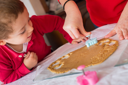 Little boy child baby and mom, baking making cookies.の写真素材