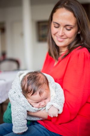 Mother taking care of a little mixed race blue eyes baby.の写真素材
