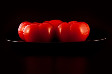 five tomatoes on the black plateの写真素材