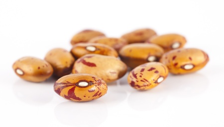 A few grains of yellow colored beans on a white background.
