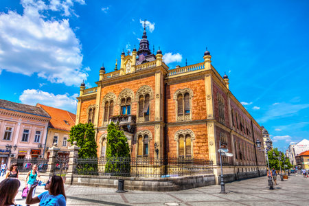 SERBIA, NOVI SAD - MAY 12, 2012: Eparchy of Backa Bishop's residence, shops, tourists and passers, the center of Novi Sad. Center of the old part of Novi Sad, sparkles spring sunshine, HDR Image.のeditorial素材