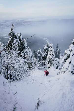 Winter Steep Slope Path Down the Mountain with Snow and personの写真素材