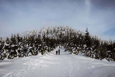 Way to the Top of the Mountain Peak with Transmitter and Blue Skies with Snowの写真素材