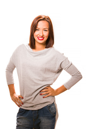 Brown hair beautiful woman with hands on hips wearing grey shirt and jeans.の写真素材