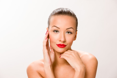 Brown sleek hair beautiful woman with hands close to face.の写真素材