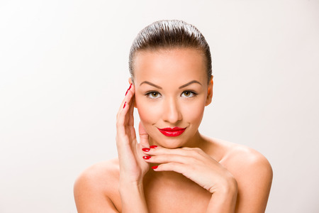 Brown sleek hair beautiful woman with hands close to face.の写真素材