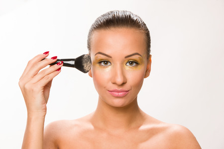 Make up. Brown sleek hair beautiful woman with fan brush close to face.の写真素材