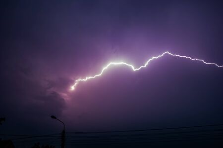 Lightning crossing the clouded sky at the evening.の写真素材