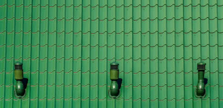 Roof tiles pattern painted green with 3 steel chimes places in symmetrical distanceの写真素材