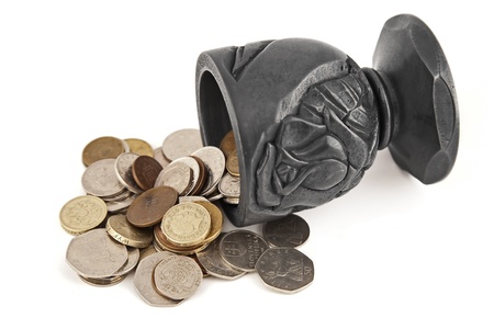 various coins spilling from the cup made of coalの写真素材