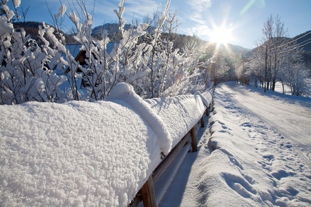 the sun setting over the road in a winter landscapeの写真素材
