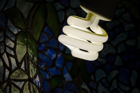 compact fluorescent bulb illuminating a lamp shade tiffany styleの写真素材