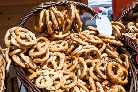 fresh pretzel sprinkled with poppy seeds placed in wicker basketの写真素材