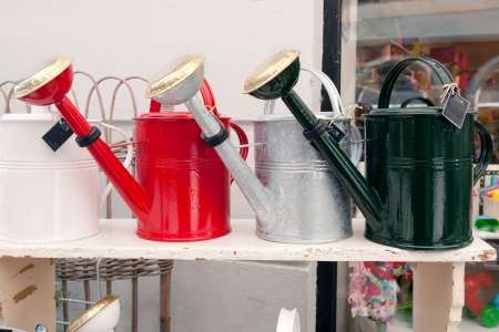 watering cans are put on display at the shop with a variety of goodsの写真素材
