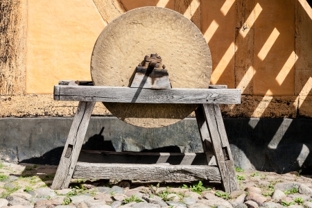 Mounted on a wooden frame of an old grinding stone, used for sharpening metal objects.の写真素材