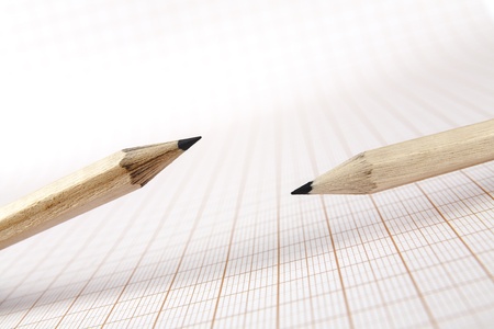 Two wooden pencils on graph paper backgroundの写真素材