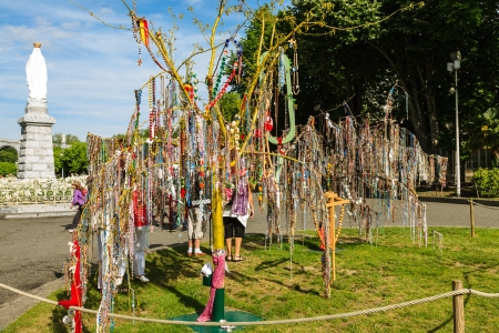 LOURDES - JUNE 06: Tree of Rosaries place of intentions submission of the faithful next to The Statue of the Crowned Virgin in front of The Basilica of the Rosary in Lourdes in France on June 06, 2012のeditorial素材