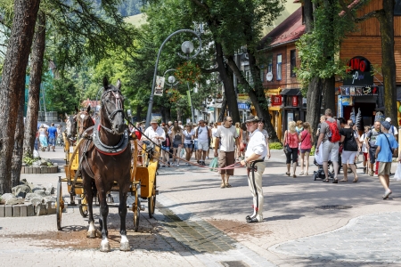 ZAKOPANE - JULY 18  Coachman with harnessed horse waits for customers on the street Krupowki in main shopping area and pedestrian promenade in the city center in Zakopane in Poland on July 18, 2013のeditorial素材