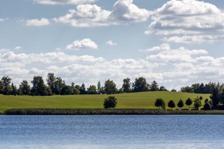 Summer view of the opposite shore of the lake in Ryn, Polandの写真素材