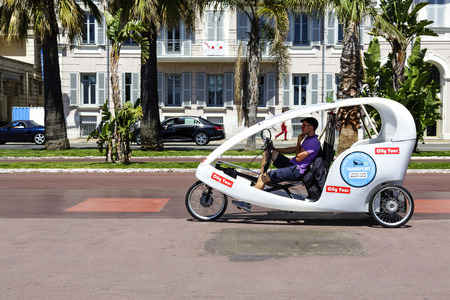 NICE, FRANCE - MAY 13, 2014: The Cyclotour, well-liked by tourists, three wheels vehicle driven by young drivers called Cyclonautes, an idea to take a city tour in environmentally friendly wayのeditorial素材