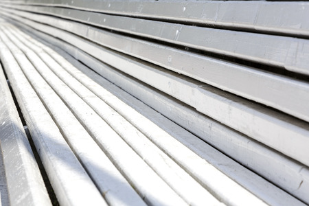 Closeup on long wooden bench creates background of converging linesの写真素材