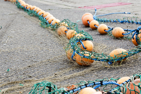 Rope with buoys from fishing nets spread over on a harbor wharfの写真素材