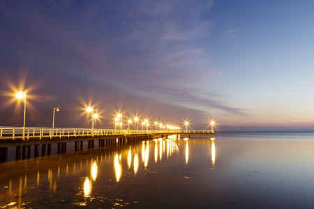 JURATA, POLAND - SEPTEMBER 11, 2014: Night view of Wooden Pier with a length of 320 meters, built in the 70s of the 20th century, located at the Baltic Sea coast at the waters of the Gulf of Puckのeditorial素材