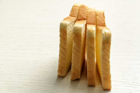 Four pieces of sliced toast bread shown on a white surface of a tableの写真素材