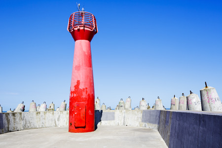 KOLOBRZEG, POLAND - JULY 17, 2015: Red navigation lighthouse, located on the breakwater eastern of...