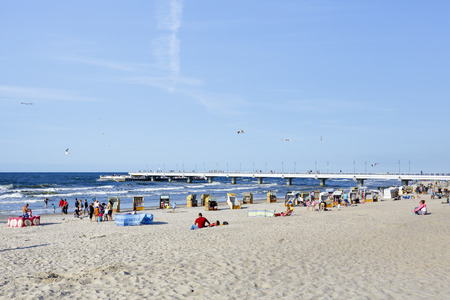 KOLOBRZEG, POLAND - JULY 15, 2015: Unidentified sunbathers enjoys the sunshine on the wide for about 100 meters sandy beachのeditorial素材