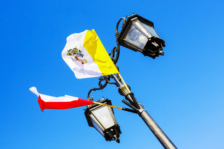 WARSAW, POLAND - OCTOBER 10, 2015: The Flag of Poland and the Flag of Vatican City in papal colors (yellow and white), officially adopted on June 7, 1929 under the Lateran treatiesのeditorial素材