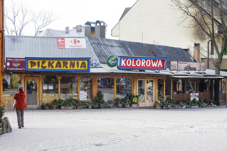 ZAKOPANE, POLAND - MARCH 09, 2016: Restaurant named Kolorowa, located in the large wooden building at main shopping area and pedestrian promenade in the downtown. The bakery can see on the leftのeditorial素材