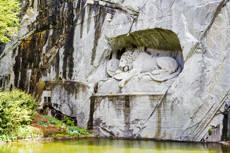 LUCERNE, SWITZERLAND - MAY 04, 2016: The monument of Dying Lion was carved in rock wall by the design of Danish artist Thorwaldsen. It is a World famous tourist attractionsのeditorial素材