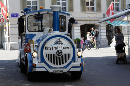 LUCERNE, SWITZERLAND - MAY 08, 2016: Blue and White Trackless Train travels through the streets of the city providing a convenient way for tourists to see variety of sightseeing attractionsのeditorial素材