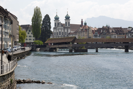 Lucerne, Switzerland - May 04, 2016: General view towards Spreuer Bridge and the Jesuit church by the Reuss river in old town. These are widely known sightseeing attractions in the city. Several people can be seen in a far distance.のeditorial素材