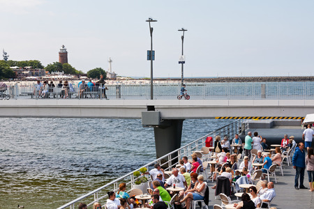 KOLOBRZEG, POLAND - JUNE 19, 2016: Unidentified vacationers enjoy the cafe placed at the end of the concrete pier, other people are resting or are walking along the jettyのeditorial素材