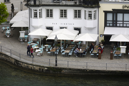 LUCERNE, SWITZERLAND - MAY 02, 2016: Aerial view towards cafe by the river. Coffee tables and white umbrellas are placed outside building in close proximity to the banks of the River Reuss.のeditorial素材