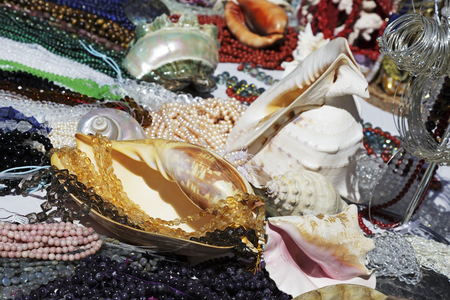 Nice, France - May 17, 2014: Various stuff on sale during the flea market which was held on one of the squares in the city. On the table a lot of shells and variety of beads can be seenのeditorial素材