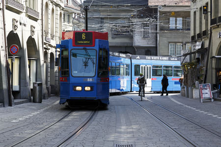 Bern, Switzerland - April 20, 2017: The blue tram turns from one street to the other in the old...