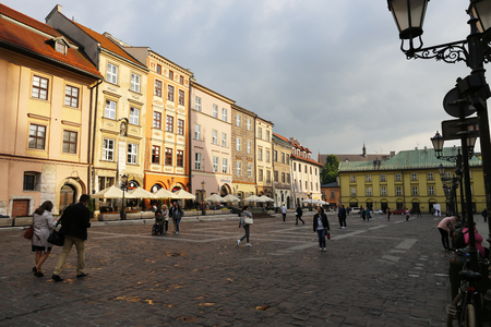 Krakow, Poland - May 25, 2017: The Small Market Square and there are walking people there. Various colorful townhouses are visible in the rays of the setting sunのeditorial素材