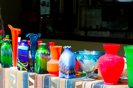 Bern, Switzerland - April 20, 2017: Artistic products such as vases and colored glass products are put up for sale and have been placed on the table which is covered with a fabricのeditorial素材