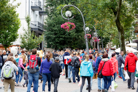 Zakopane, Poland - August 07, 2017: Tourists walk along Krupowki Street during the holiday season. Countless number of people, street lamps and green trees can be seenのeditorial素材
