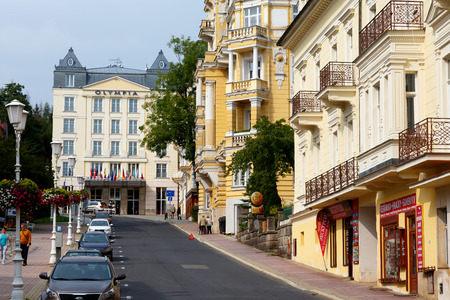 Marianske Lazne, Czechia - September 09, 2017: Cityscape shows townhouses with beautiful architectural decorations. Along the street, a few cars were parked and people are thereのeditorial素材