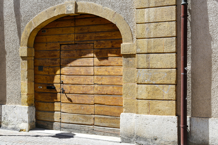 Yverdon-les-Bains, Switzerland - 18 April 2017: Wooden entrance gate with a door. The gateway is made of thick boards and there are three different address numbers.のeditorial素材