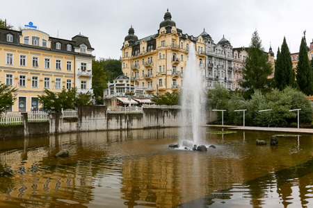 Marianske Lazne, Czechia - September 10, 2017: Fountain on the water in the urban space near the beautiful tenement houses. This view can be seen during a cloudy day in this beautiful spa townのeditorial素材